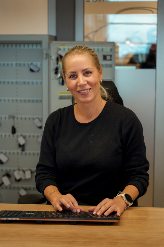 Jente som sitter foran pc i bilverksted