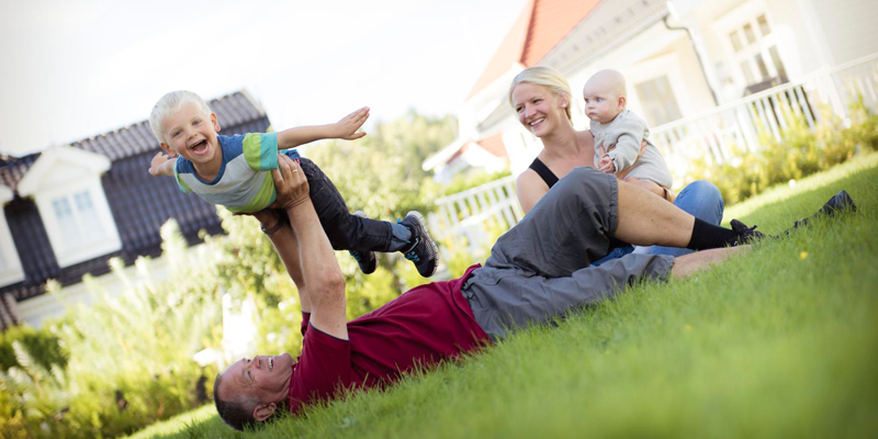 Familie på plenen forran huset
